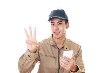 スマートフォンを持つ作業員