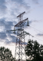 electricity transmission pylon at city suburb against the sunset glow sky.