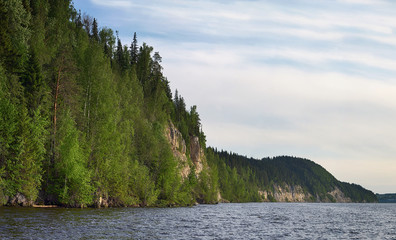 Rocky river is covered with forest.