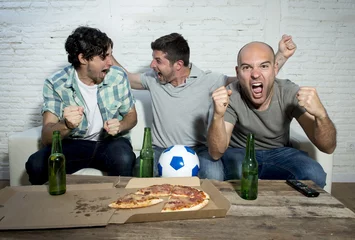 Fotobehang friends fanatic football fans watching game on tv celebrating goal screaming crazy happy © Wordley Calvo Stock