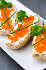 Red caviar on bread on white plate.