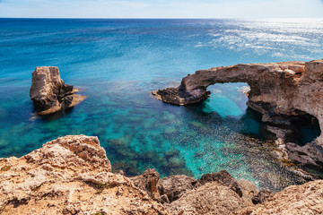 Beautiful natural rock arch near of Ayia Napa, Cavo Greco and Protaras on Cyprus island, Mediterranean Sea. Legendary bridge lovers. Amazing blue green sea and sunny day.