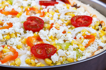 Closeup of uncooked homemade vegetarian pizza on kitchen table, raw pizza.