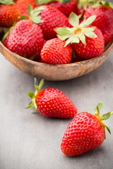 Strawberry in a bowl on the gray background.