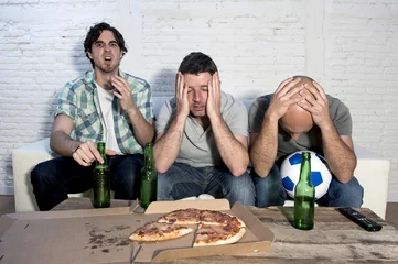 Poster sad frustrated friends fanatic football fans watching tv match with beer dejected © Wordley Calvo Stock