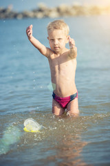 Little boy with snorkel by the sea. Cute little kid wearing mask and flippers for diving at sand tropical beach. Ocean coast.