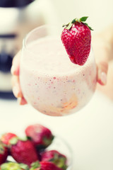 close up of hand holding glass with fruit shake