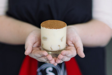 Girl holding a dessert of tiramisu