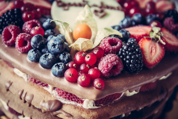 layer cake with mixed berries on top for for celebration event
