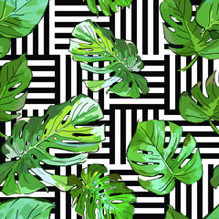 Green palm tree leaves on black and white geometric background. Vector summer seamless pattern. Hand drawn tropical leaves background. Design for fabric, textile print, wrapping paper or web. 