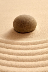 Fototapeta na wymiar Close up of single stone in zen garden with sand
