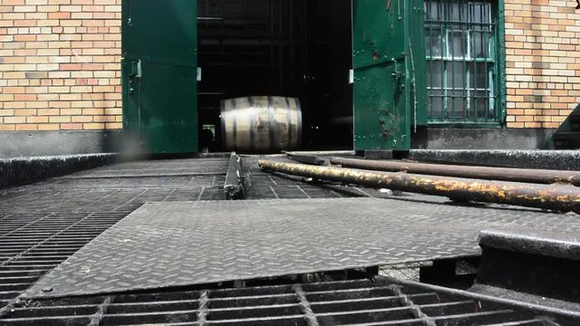 Bourbon Barrel Rolling on Track outside of brick distillery building