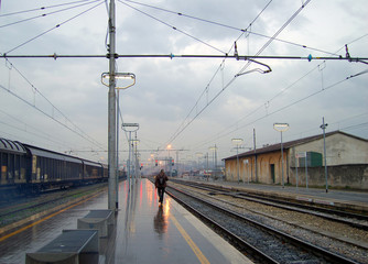 Fototapeta premium uomo cammina alla stazione dei treni