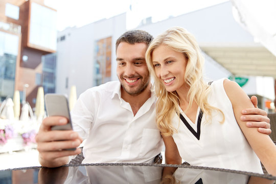 couple taking selfie with smatphone at restaurant