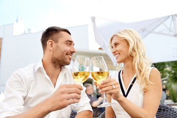 happy couple drinking wine at open-air restaurant
