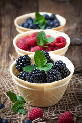 Blackberries, raspberries and blueberries in a waffle bowls.