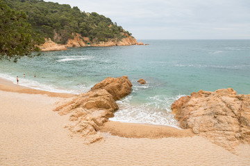 Bay of Tamariu, Spain, with three swimmers