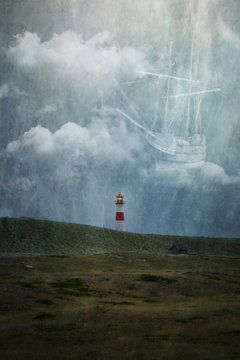 Lighthouse on hillside, image of ship in clouds