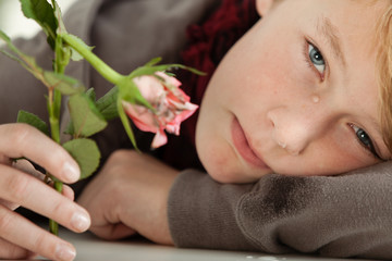 Obraz na płótnie Canvas Teenage Boy Crying and Holding Broken Pink Rose