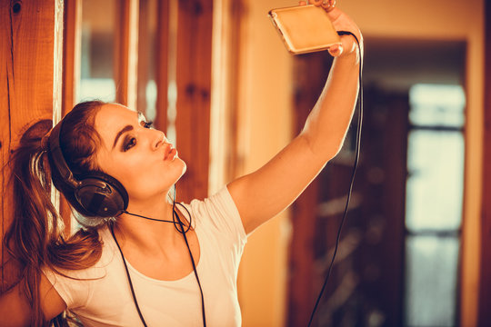 Woman with headphones smartphone listening music.