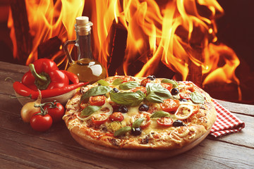 Delicious fresh pizza on fire flame background