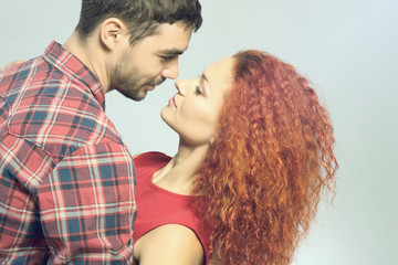 Happy young couple in love embracing on grey background, close up