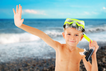Happy boy with yellow diving mask on blurred sea background