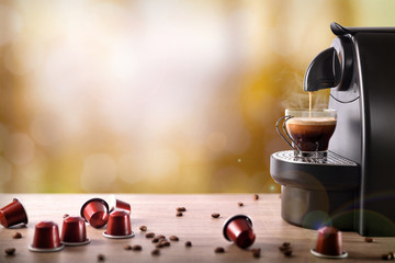 Espresso machine making coffee on wood table front view