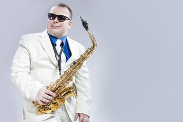 Naklejka premium Portrait of Passionate Expressive Male Alto Saxophone Player in Sunglasses Against White