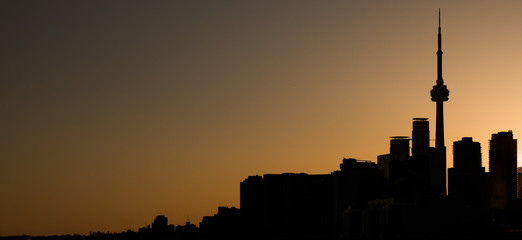 SILHOUETTE OF TORONTO SKYLINE AGAINST AN ORANGE SKY AT SUNSET