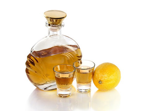 Bottle with shot glasses tequila and lemon on white background