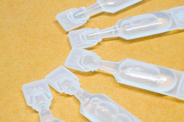 Artificial tear single use containers eye drop on yellow paper t