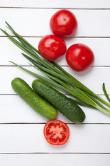 Fresh vegetable on wooden vintage table. tomato, cucumber and green onion