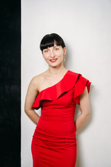 Beautiful young model woman in red dress posing over white backg