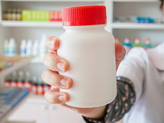 Female pharmacist hold medicine bottle