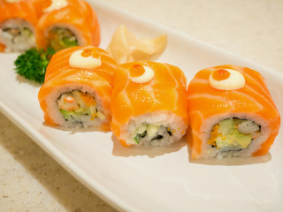 Sushi rolls with salmon on white plate