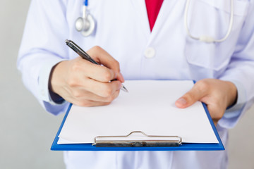 Medical doctor writing prescription on white isolated background (Focus on clipboard)