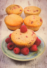 Vintage photo, Fresh baked cupcake with raspberries and fruits on old wooden background, delicious dessert
