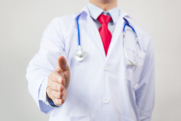 Medical doctor reaching hands out and giving a handshake on white isolated background