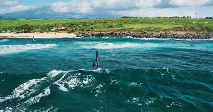 Aerial view of windsurfer gliding across blue ocean, extreme sport