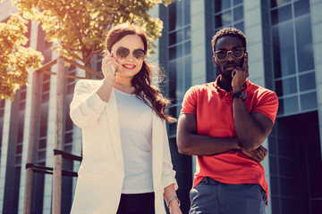 Female with smartphone in a company with afro american guy.