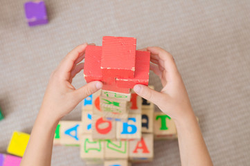 Red cross of cubes by kid hands