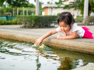 Fototapeta premium Beautiful young girl child fing something in the pool