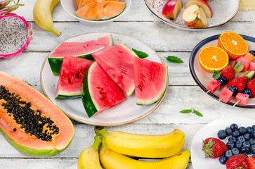 Preparing fruit salad on white wooden  background.