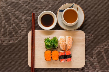 Sushi set with chop sticks and soy sauce served on wooden slate