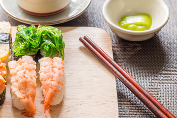 Sushi set with chop sticks, wasabi served on wooden slate, selec
