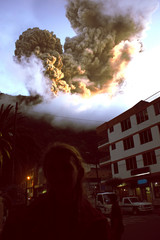 girl in red coat and Eruption of a volcano Tungurahua, Ecuador