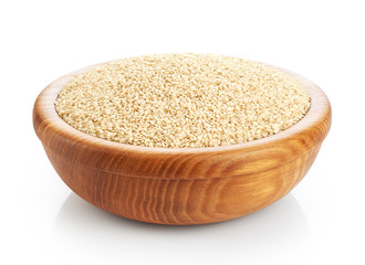Wooden bowl with sesame seeds isolated on white background.