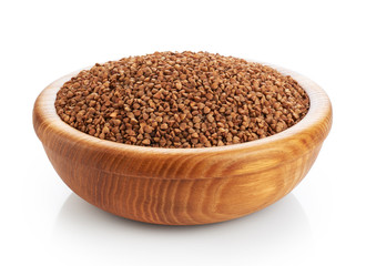 Wooden bowl with buckwheat isolated on white background.