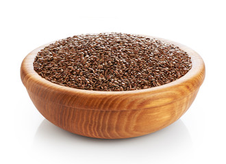 Wooden bowl with linen seeds isolated on white background.